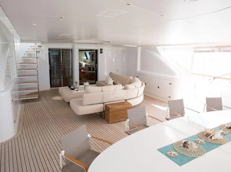 a large living room with a large table and chairs aboard PANTHALASSA Yacht for Sale