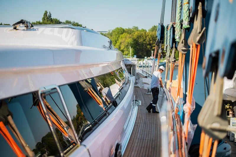 a person walking on a sidewalk next to a boat aboard PANTHALASSA Yacht for Sale