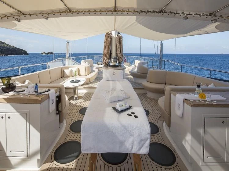 a room with a bed and a table aboard PANTHALASSA Yacht for Sale