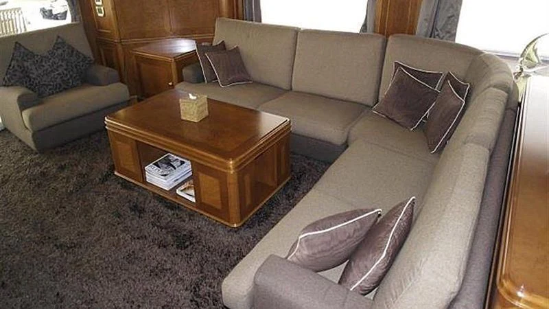 a living room with a couch and coffee table aboard BENETTI TRADITION 100 Yacht for Sale
