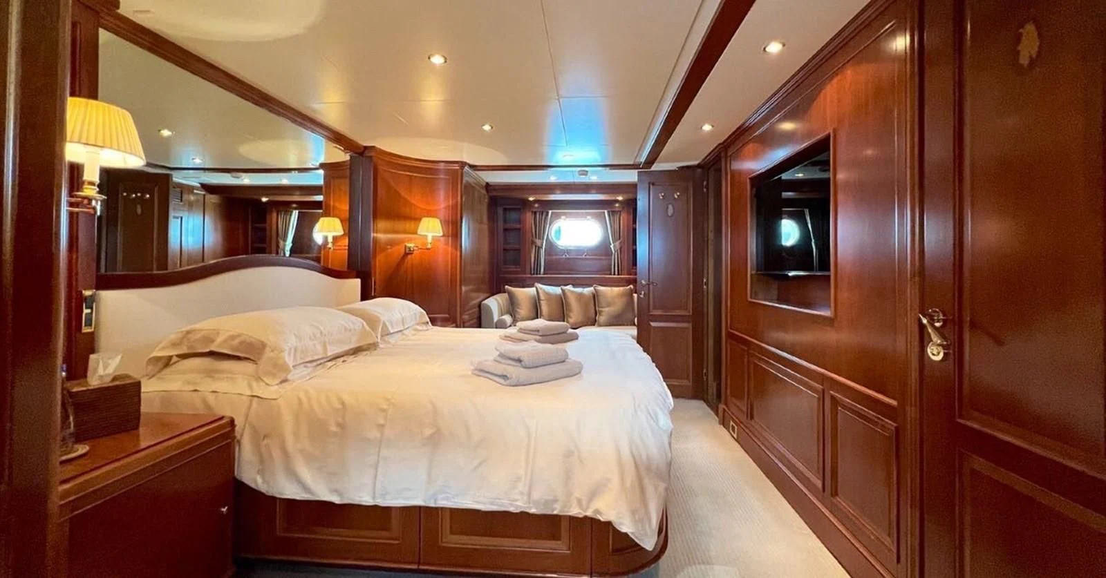 a hotel room with a bed and a wood cabinet aboard BENETTI TRADITION 100 Yacht for Sale
