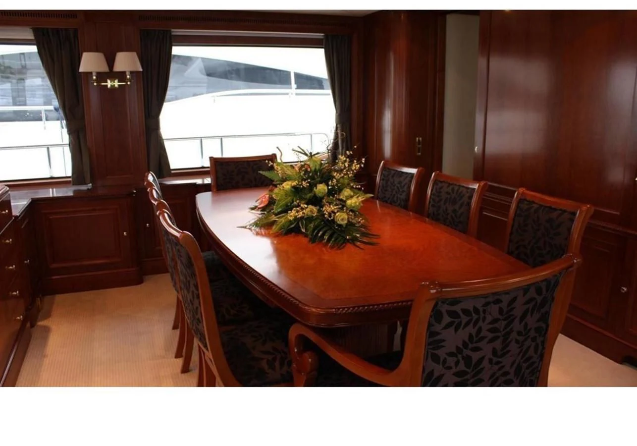 a dining table with chairs and a plant on it aboard BENETTI TRADITION 100 Yacht for Sale