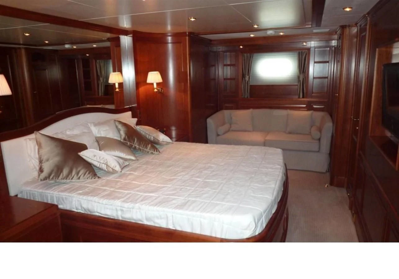 a bed with a couch and a television in a room aboard BENETTI TRADITION 100 Yacht for Sale