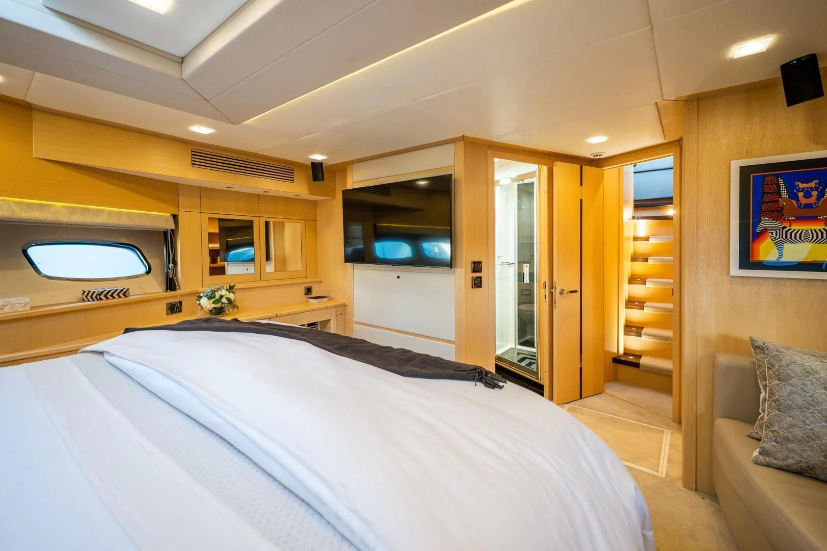 a bedroom with a bed and a television aboard THE KING Yacht for Sale