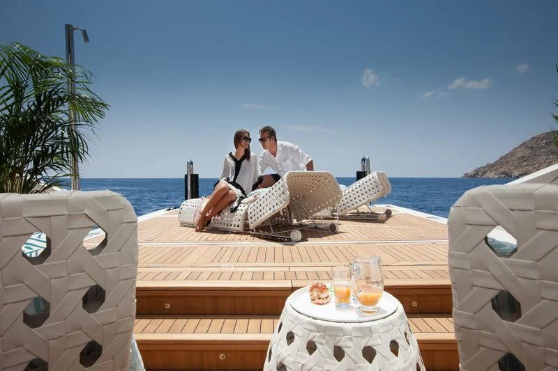 a couple sitting on a deck aboard SARAMOUR Yacht for Sale
