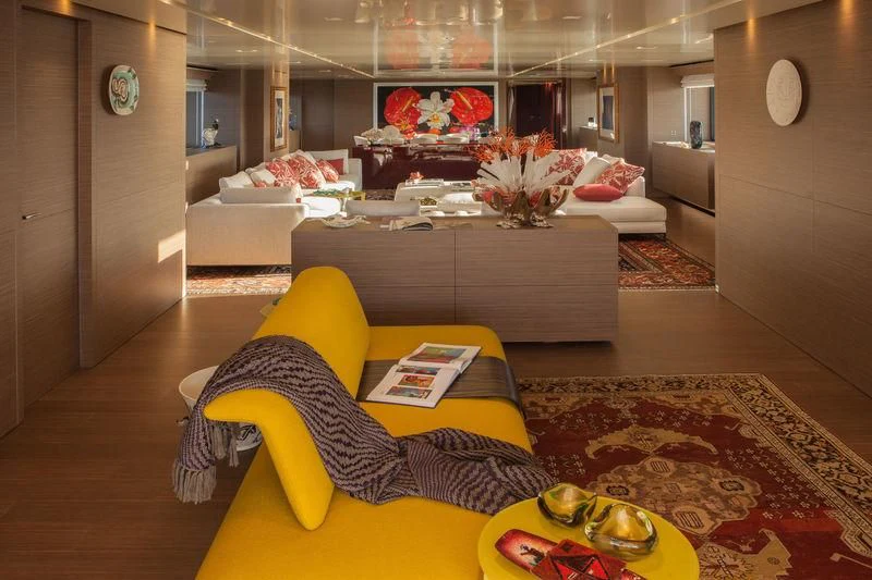 a living room with a yellow couch and a yellow chair aboard SARAMOUR Yacht for Sale