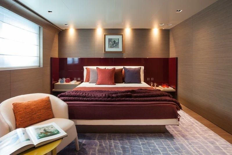 a bed with a red and black bed spread aboard SARAMOUR Yacht for Sale