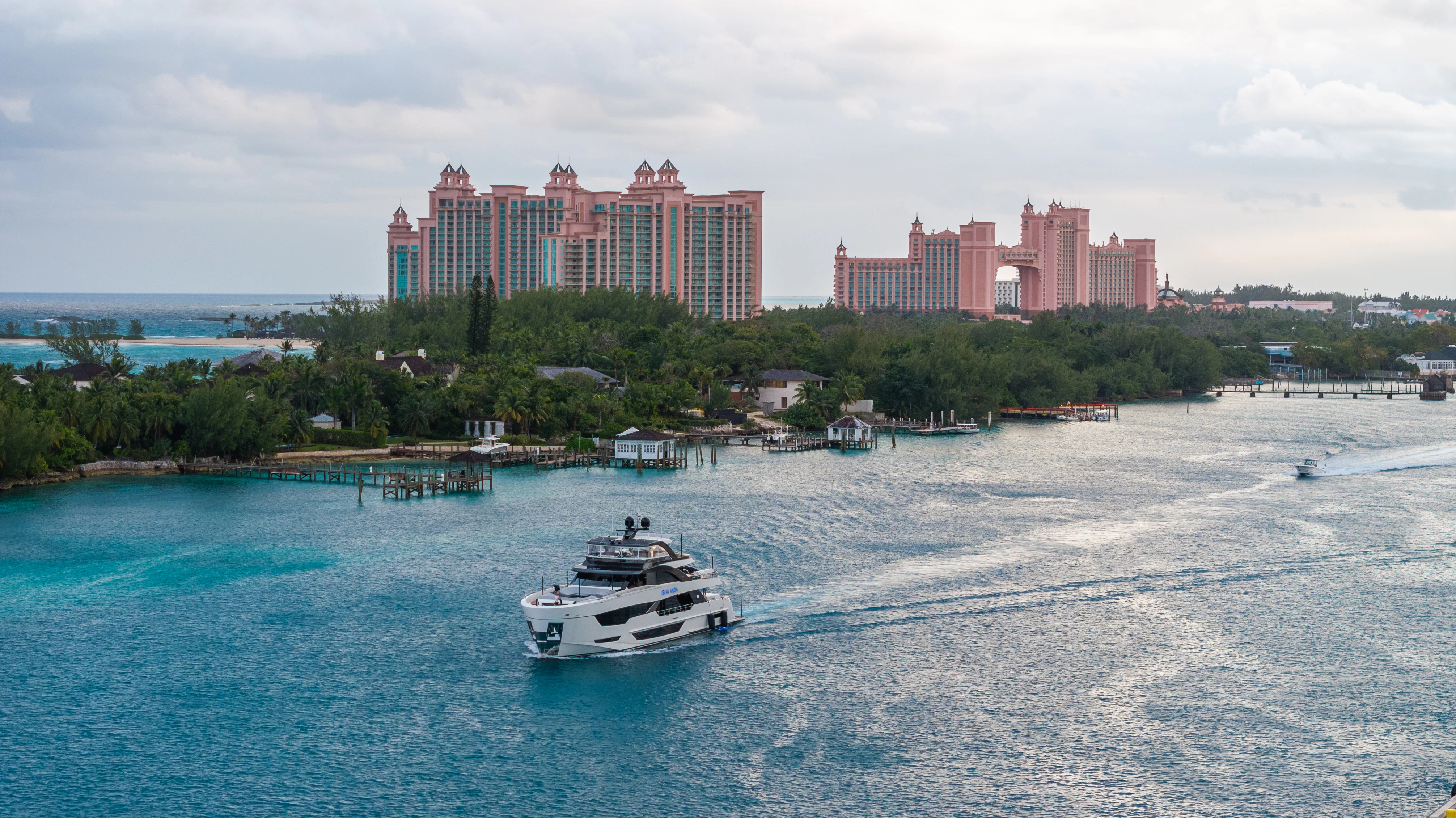 a boat sailing on the water with Atlantis Paradise Island in the background aboard BOA VIDA Yacht for Sale