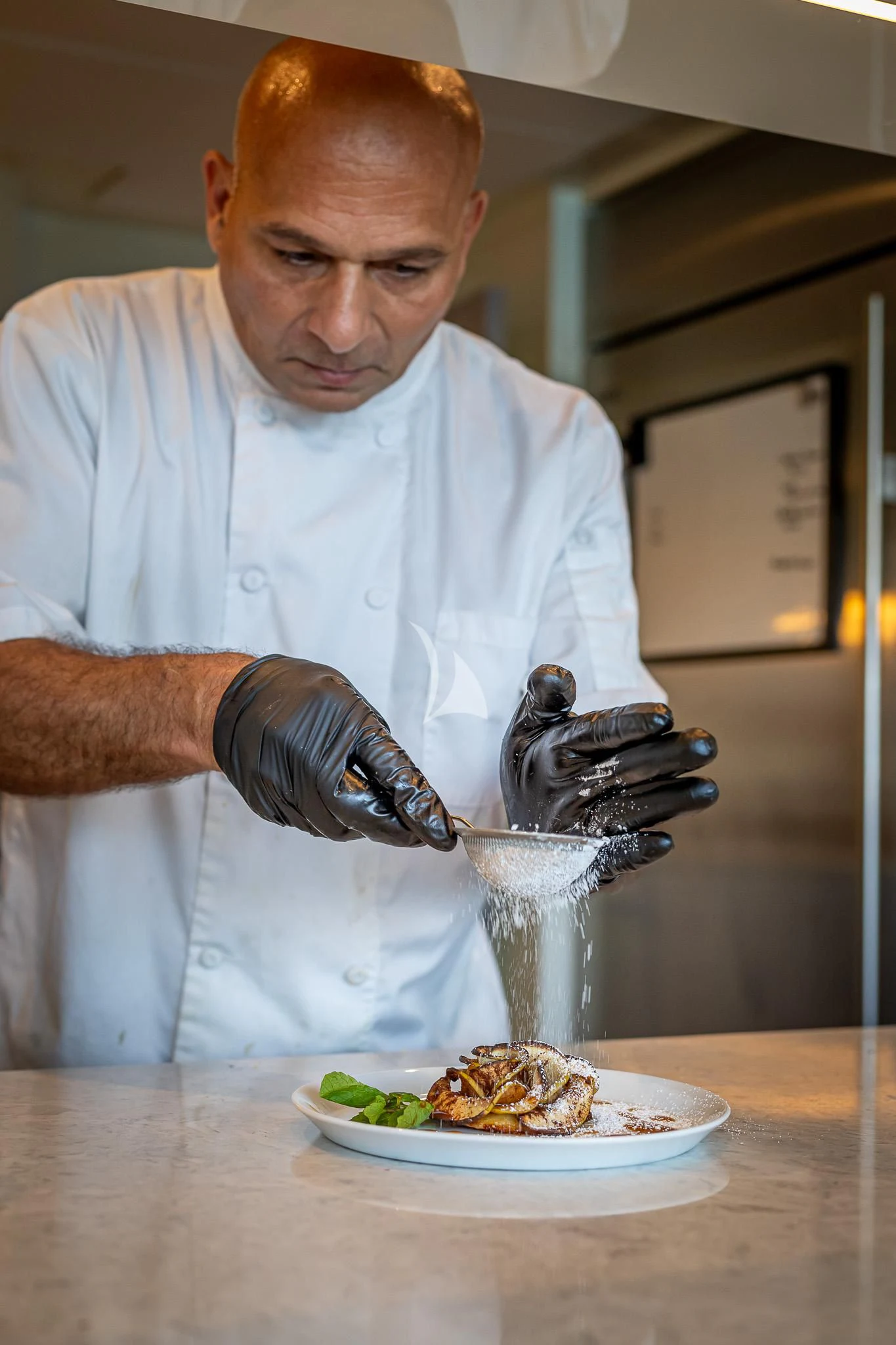 a man pouring a liquid into a glass aboard BOA VIDA Yacht for Sale