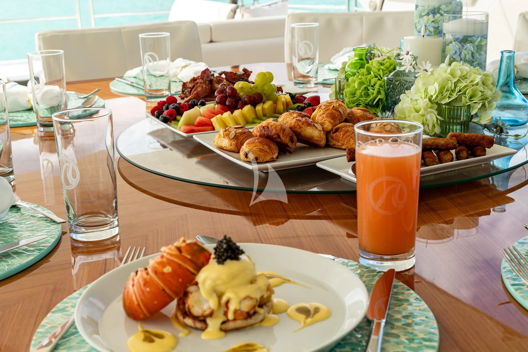 a table with plates of food and glasses of liquid on it aboard BOA VIDA Yacht for Sale