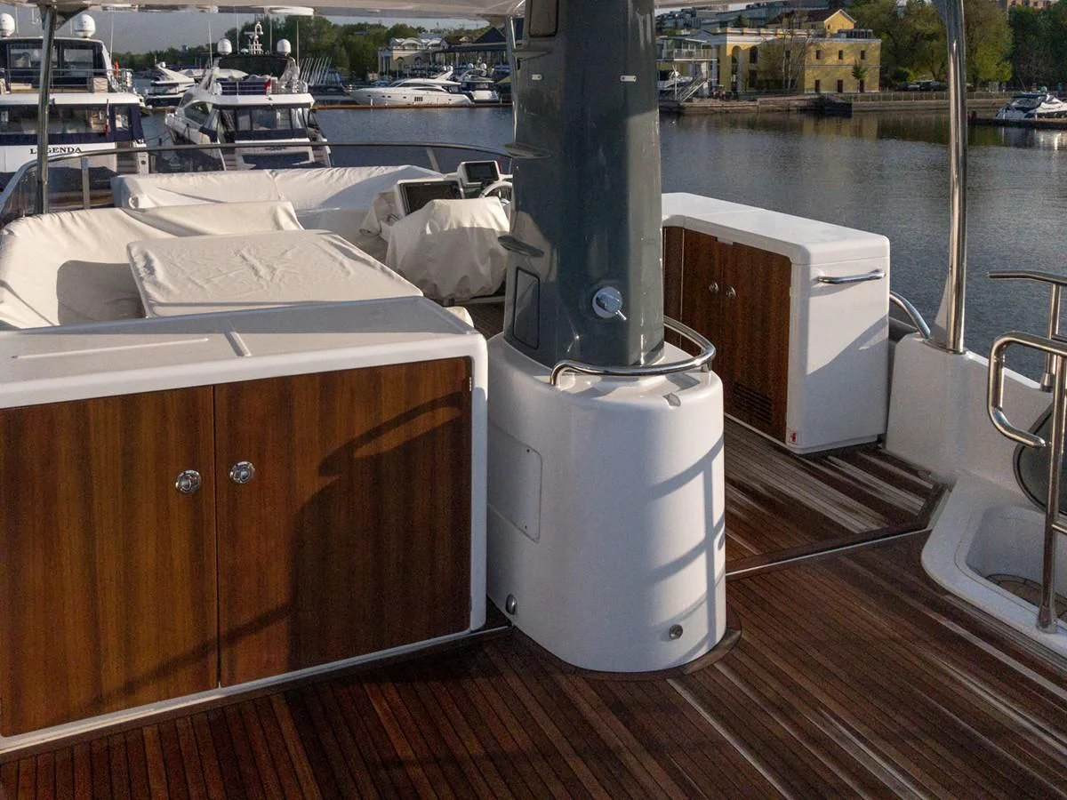 a wood deck with a white table and a white box on it aboard MAGELLANO 66 Yacht for Sale
