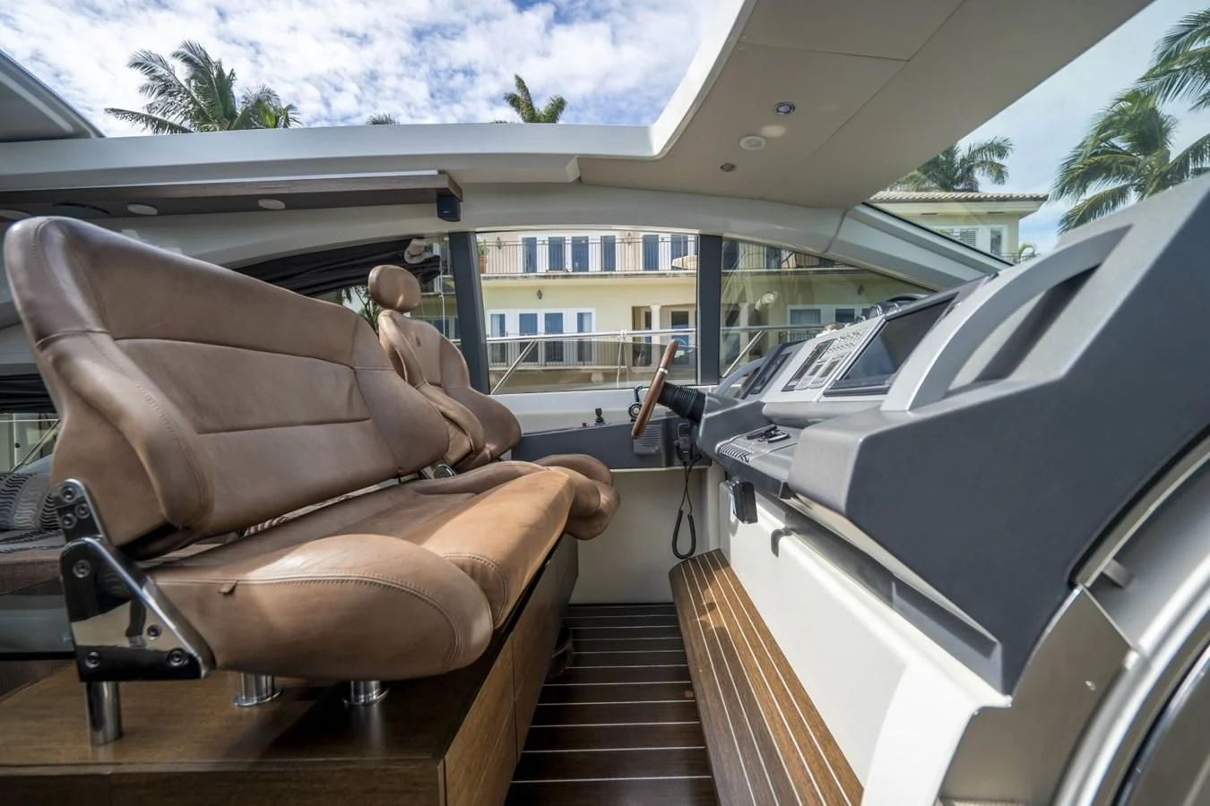 a person sitting on a chair next to a car aboard KNOTORIOUS IV Yacht for Sale