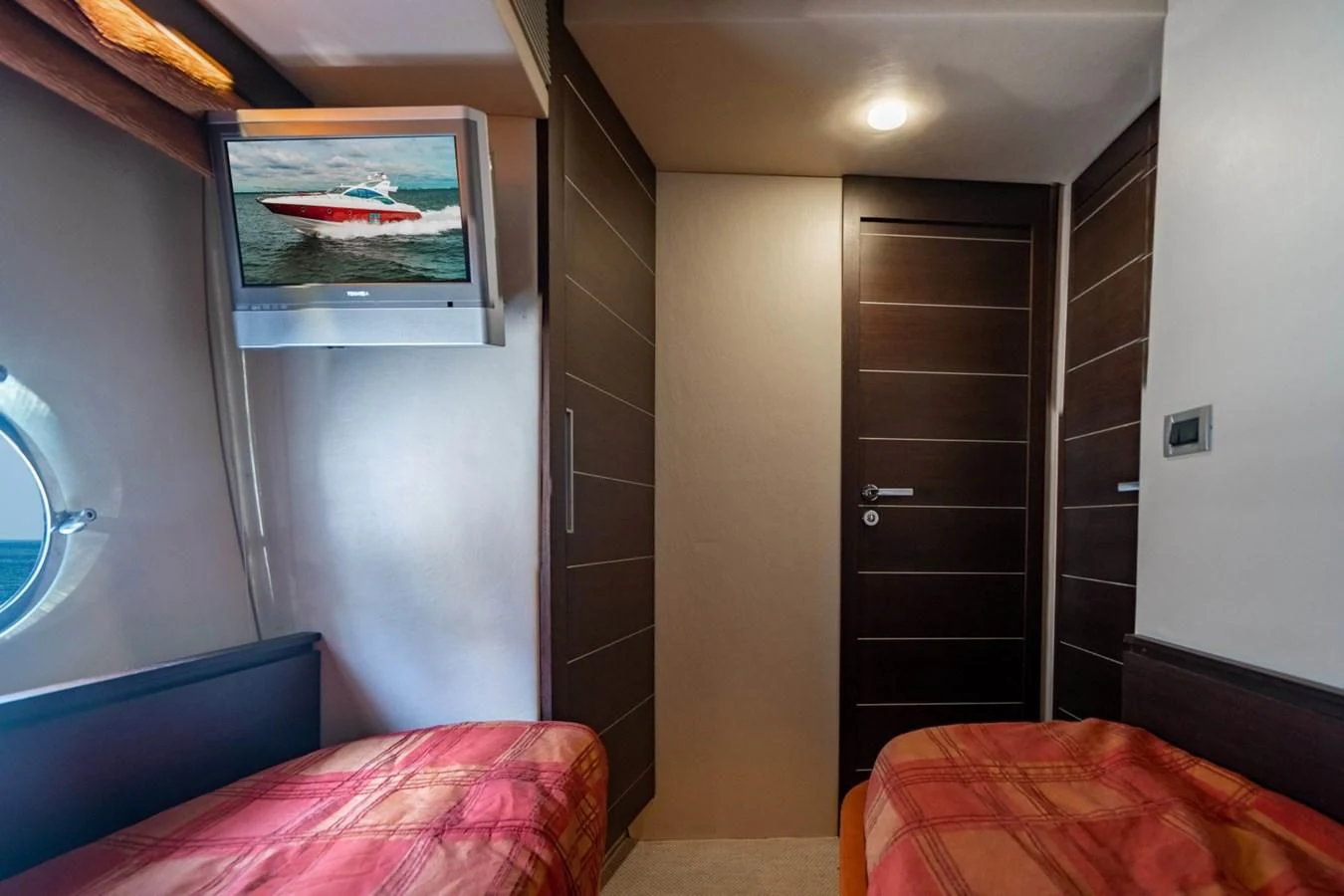 a bedroom with a tv on the wall aboard KNOTORIOUS IV Yacht for Sale