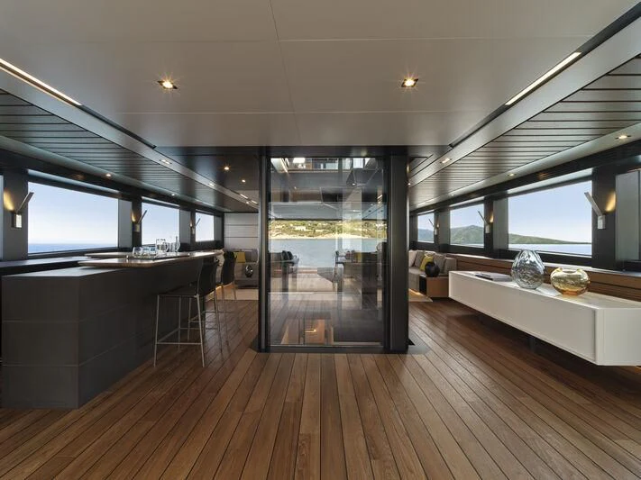 a room with a wood floor and a large window with a view of the city aboard TELL ME WHY Yacht for Sale