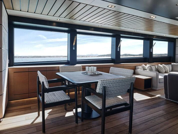 a table and chairs on a deck aboard TELL ME WHY Yacht for Sale