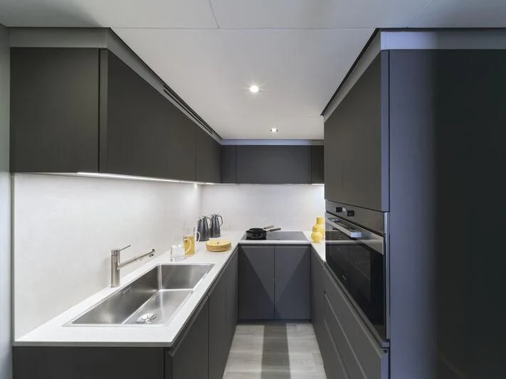 a kitchen with black cabinets aboard TELL ME WHY Yacht for Sale