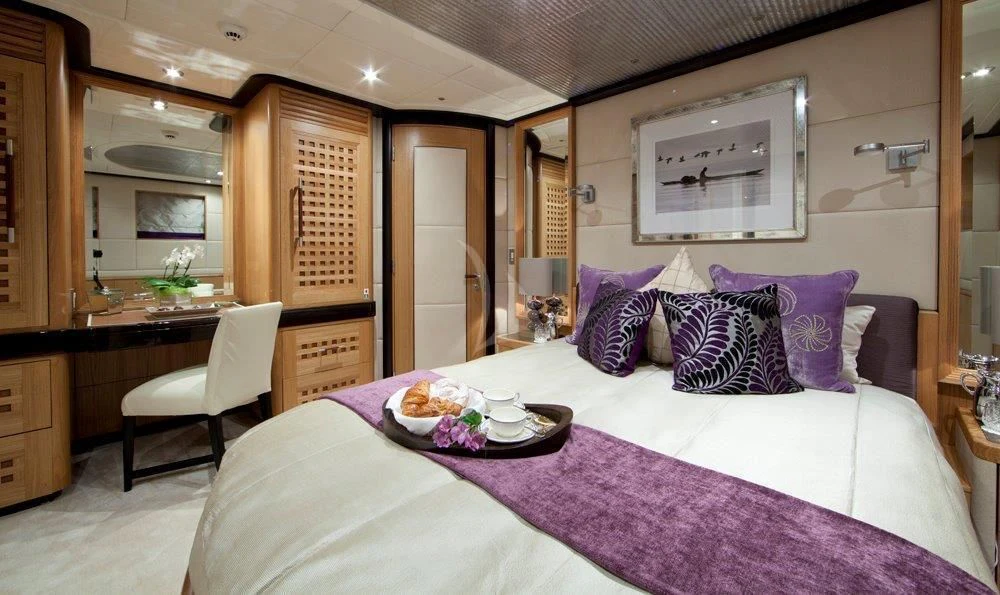 a bed with purple sheets aboard BIG CHANGE II Yacht for Sale