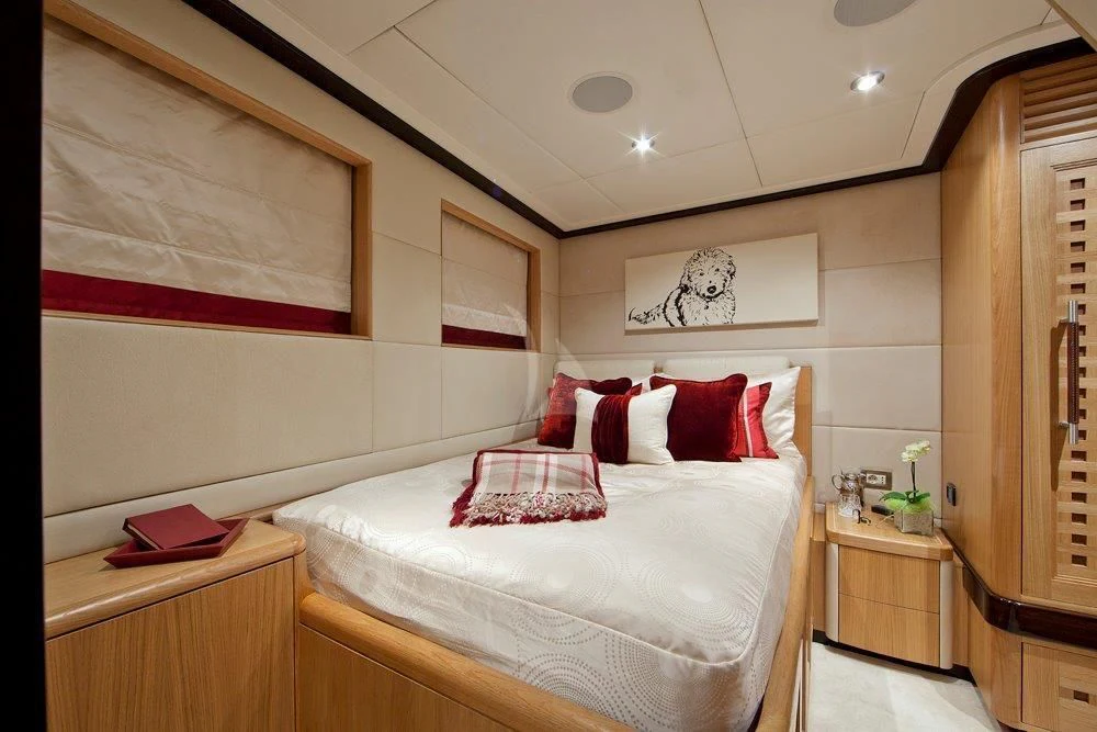 a bedroom with a bed and a painting on the wall aboard BIG CHANGE II Yacht for Sale