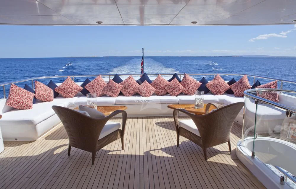 a table and chairs on a deck overlooking a large body of water aboard BIG CHANGE II Yacht for Sale