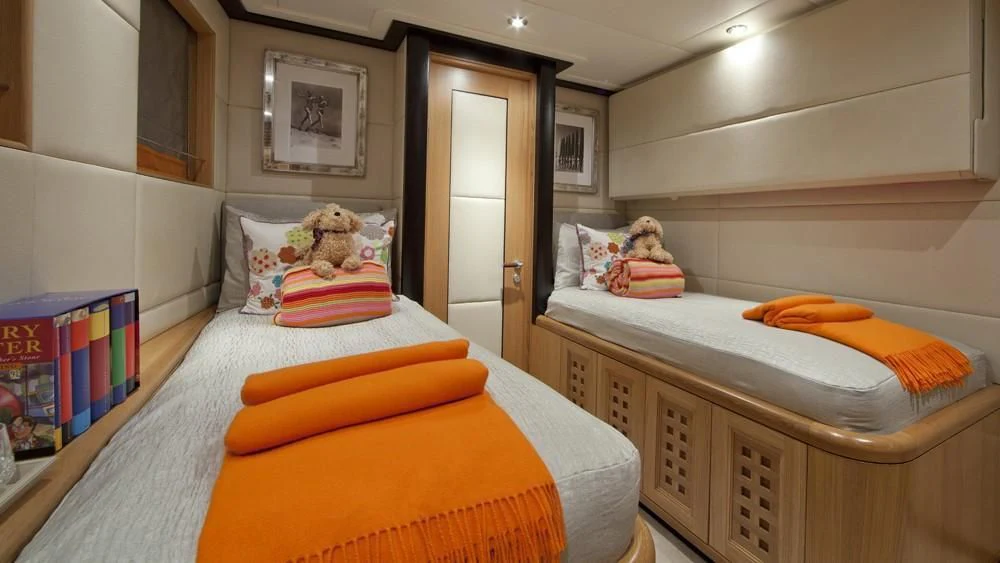 a bedroom with a bed and a bookcase aboard BIG CHANGE II Yacht for Sale