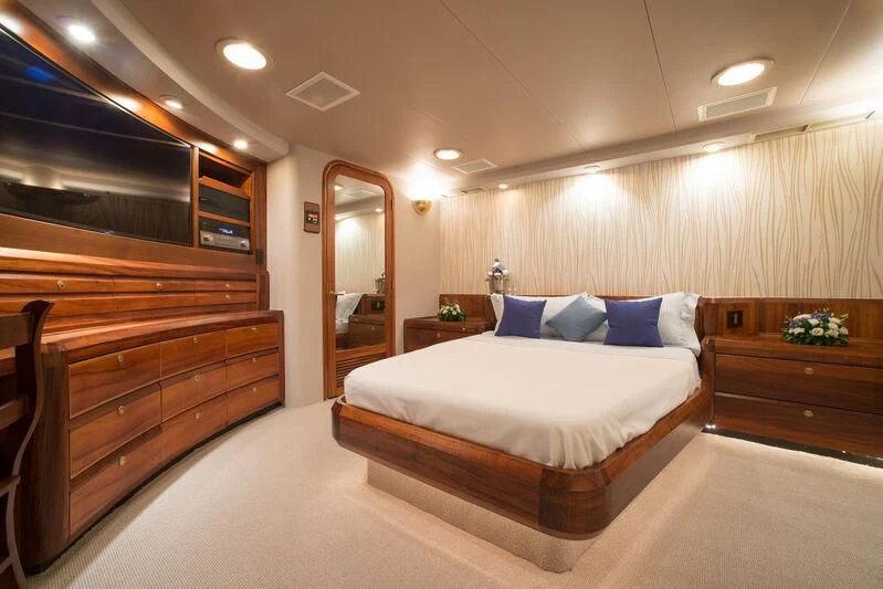 a bedroom with a bed and a dresser aboard GOLDEN OSPREY Yacht for Sale