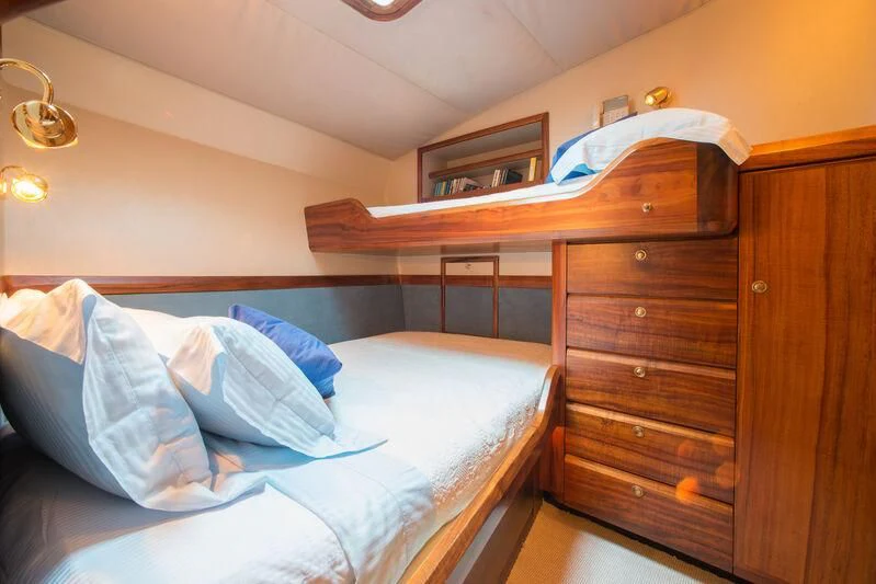 a bed with a wooden headboard aboard GOLDEN OSPREY Yacht for Sale