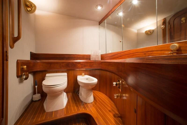 a bathroom with wooden cabinets aboard GOLDEN OSPREY Yacht for Sale