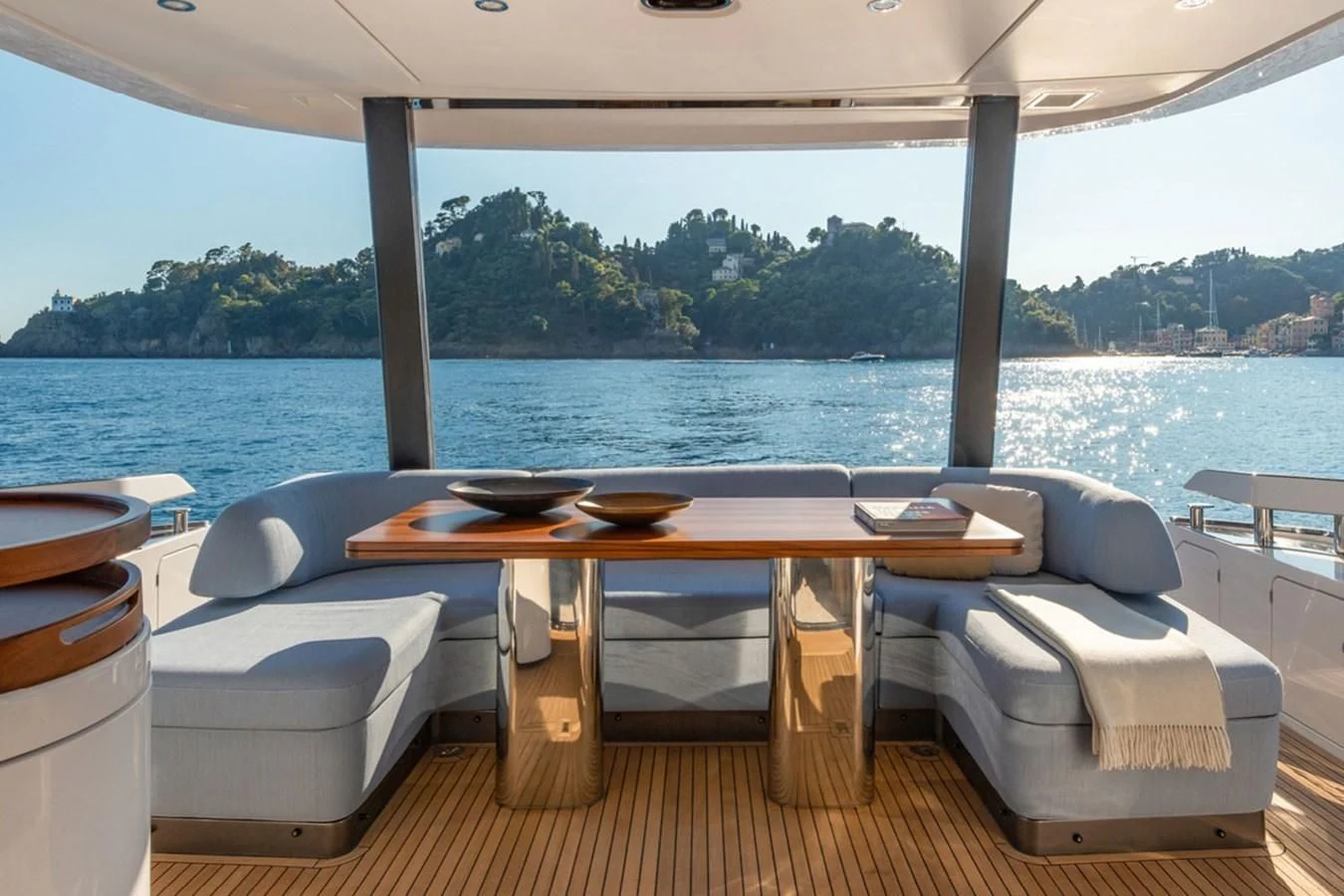 a table and chairs on a deck overlooking a body of water aboard SUNSTROKE Yacht for Sale