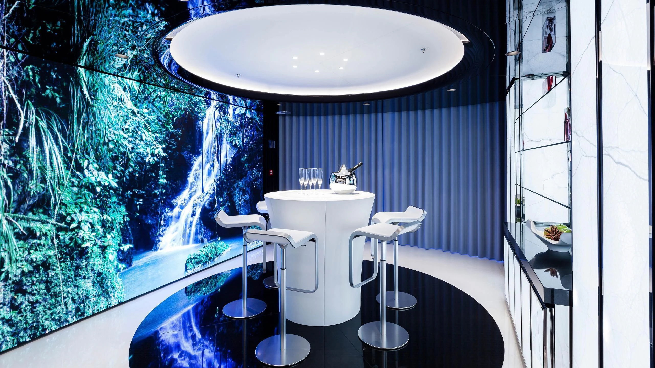 a white table with a white table and chairs in a room with a large window and plants aboard HIGH POWER III Yacht for Sale