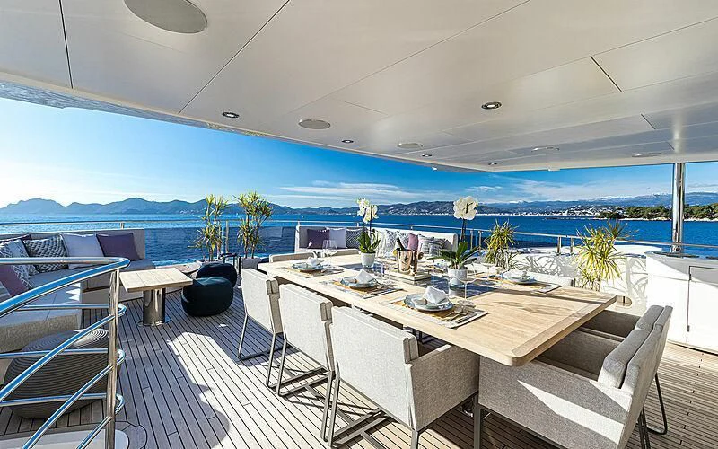 a large white table with chairs and a view of the ocean aboard THE BOAT OF FATE 2 Yacht for Sale