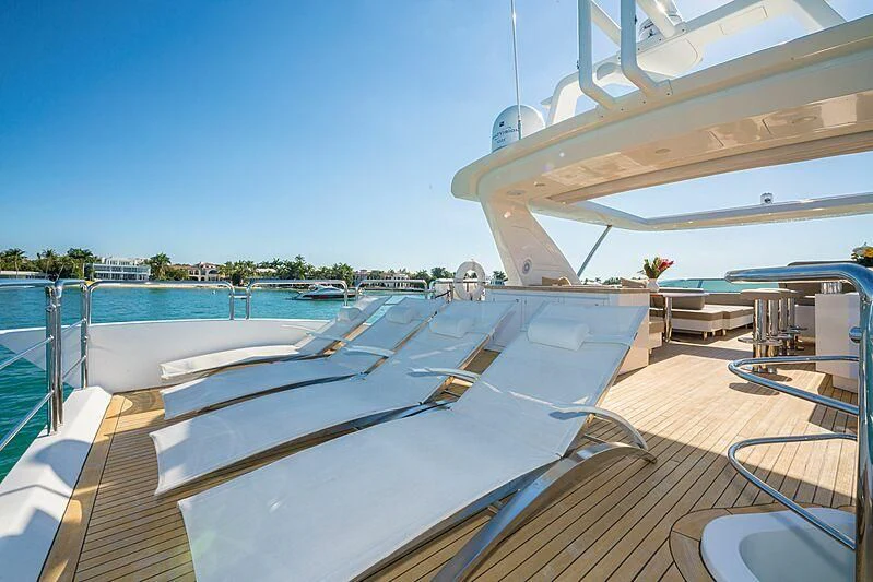 a deck with a pool and a large building in the background aboard PHOENIX Yacht for Sale