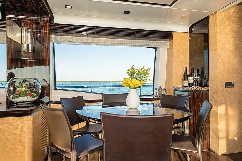 a room with a table chairs and a vase with flowers in it aboard PHOENIX Yacht for Sale