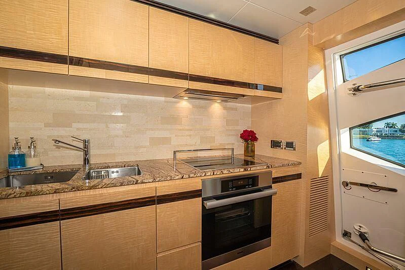 a kitchen with wooden cabinets aboard PHOENIX Yacht for Sale