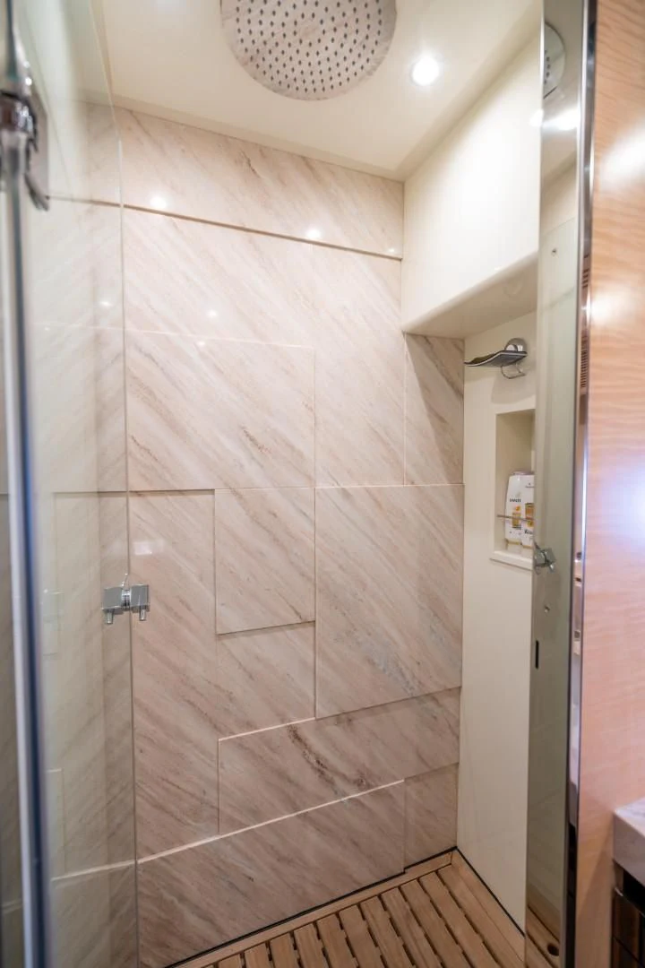 a shower with a tile wall aboard PHOENIX Yacht for Sale