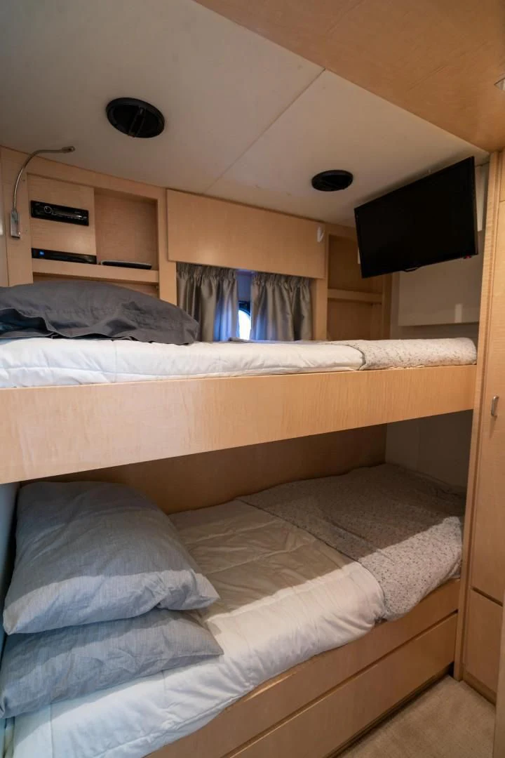 a room with a bed and a television aboard PHOENIX Yacht for Sale