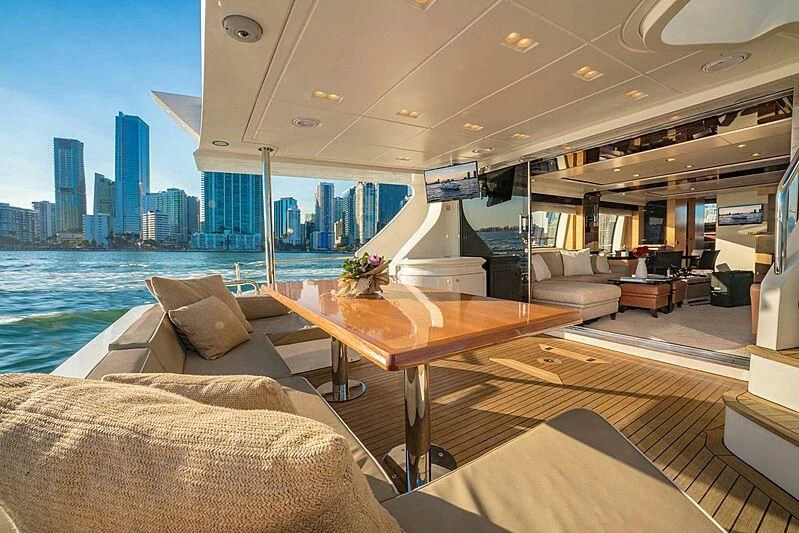 a room with a table and couches and a city skyline aboard PHOENIX Yacht for Sale
