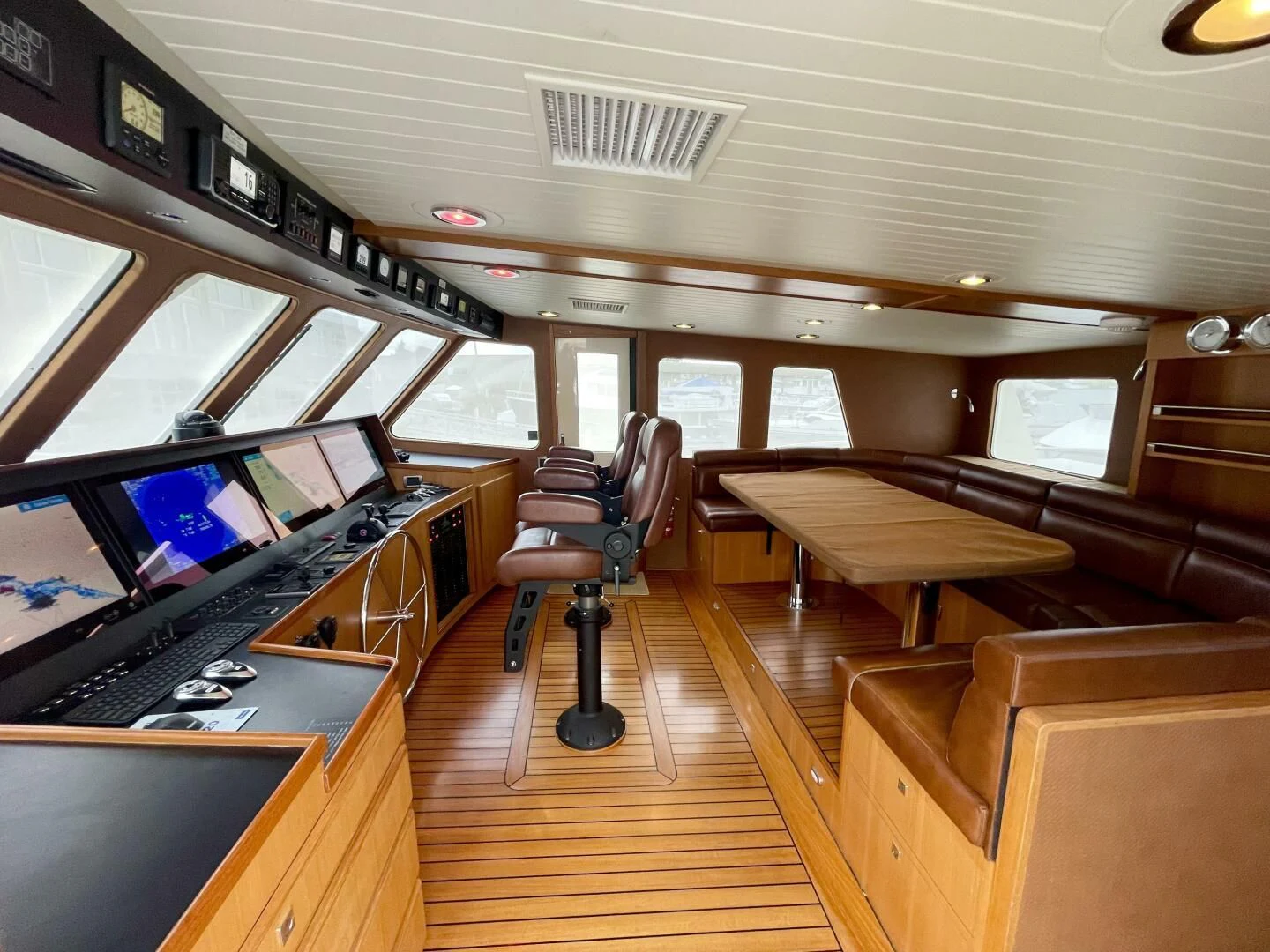a room with a wood floor and a large screen with a desk and a computer aboard SEA LION Yacht for Sale