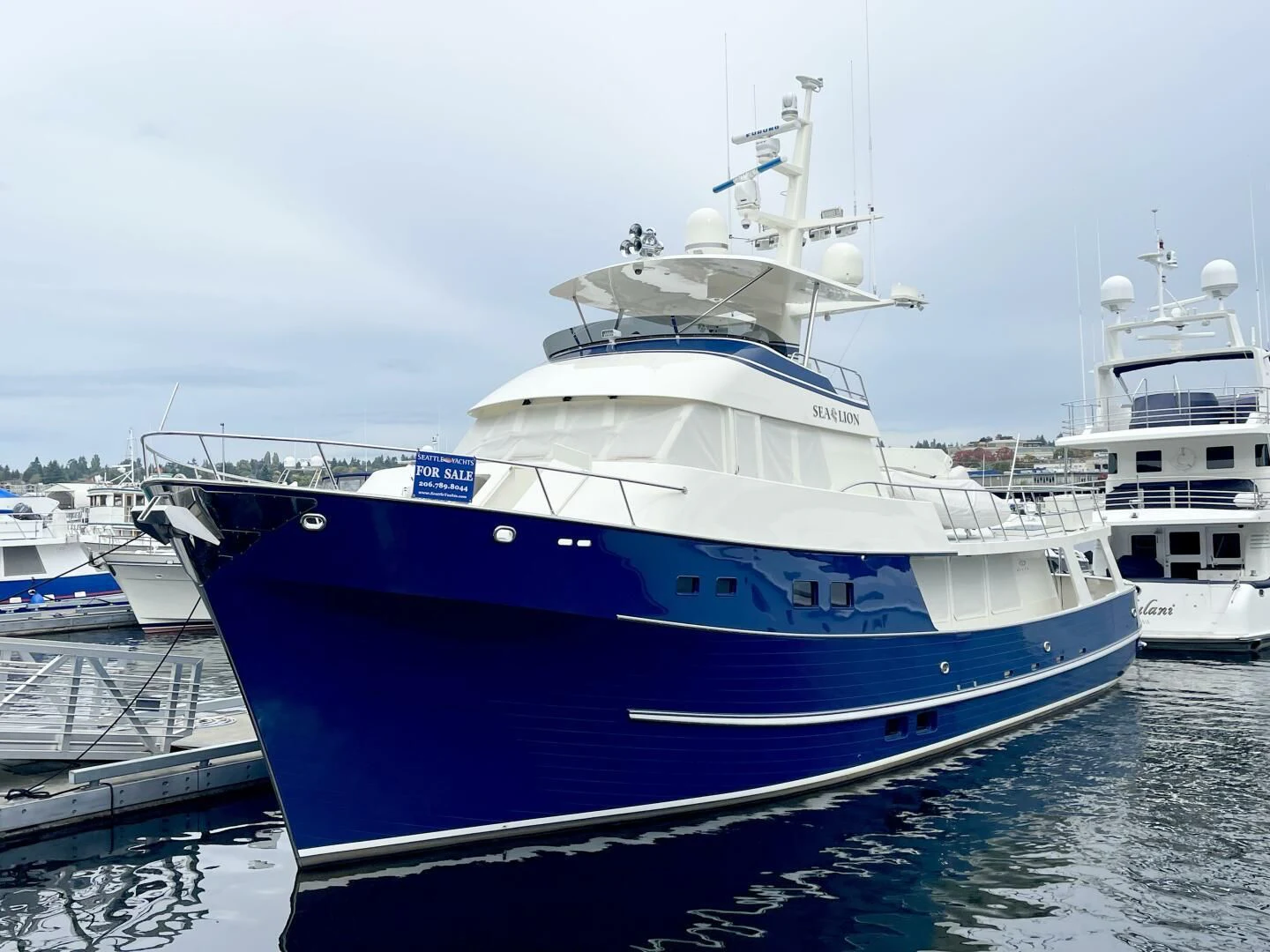 a large white boat in a harbor aboard SEA LION Yacht for Sale