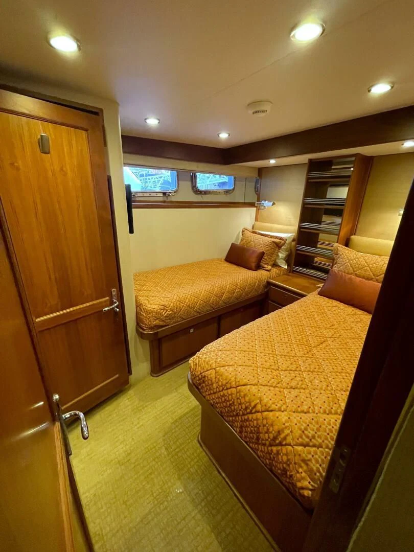 a bedroom with a bed and a bookcase aboard SEA LION Yacht for Sale