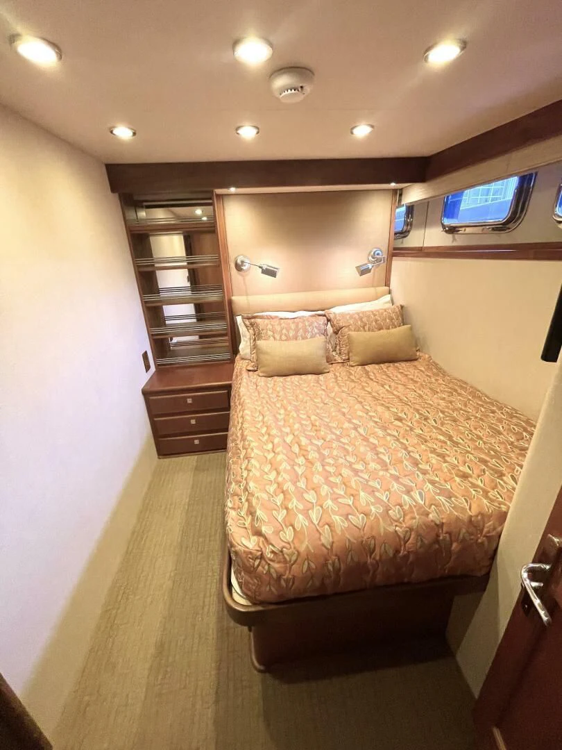 a bedroom with a bed and a bookcase aboard SEA LION Yacht for Sale