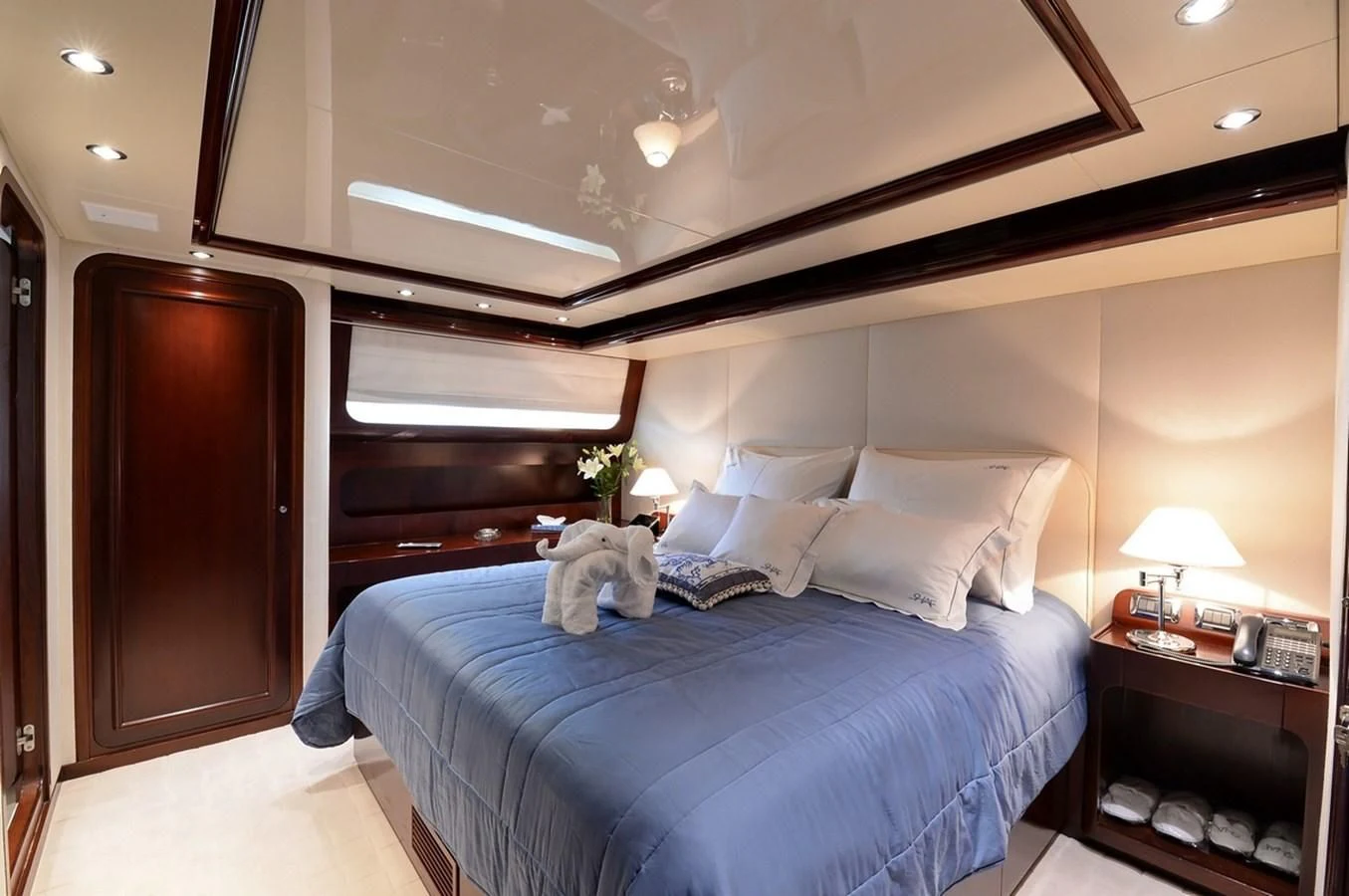 a bed with a blue comforter aboard SUITE Yacht for Sale