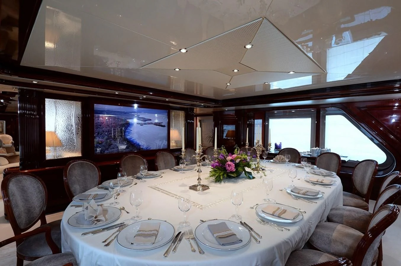 a dining room with a large screen aboard SUITE Yacht for Sale
