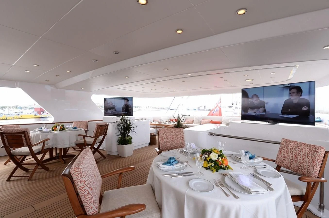 a room with tables and chairs aboard SUITE Yacht for Sale