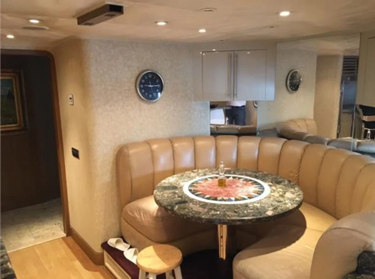a living room with a table and couches aboard MYC Yacht for Sale