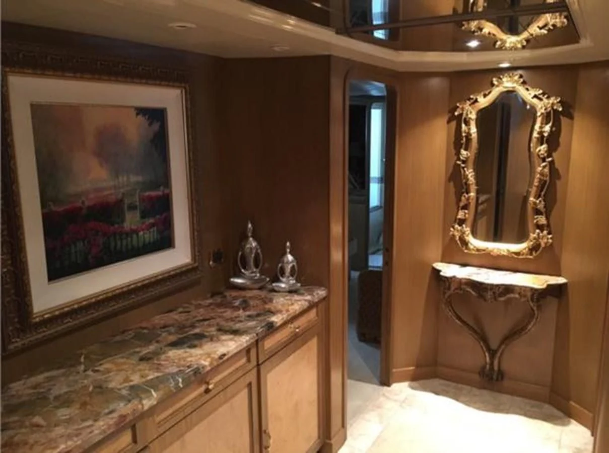 a room with a mirror and a counter with a sink and a painting aboard MYC Yacht for Sale