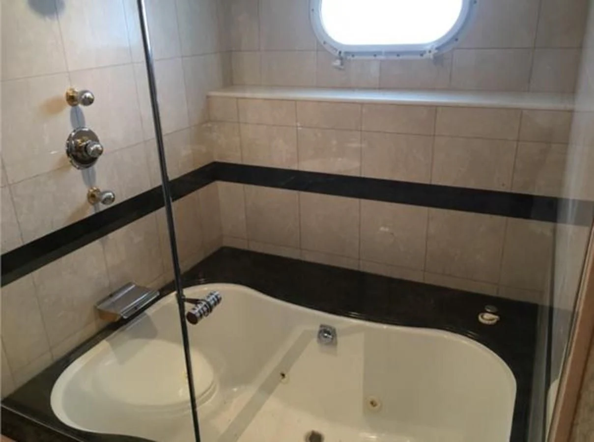 a bathtub with a black shower curtain aboard MYC Yacht for Sale