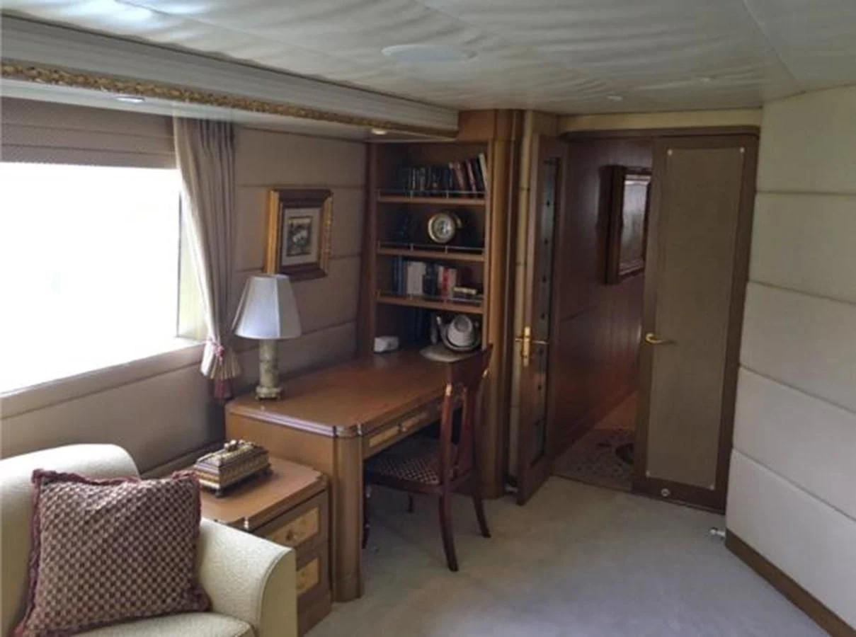 a room with a table and a couch aboard MYC Yacht for Sale