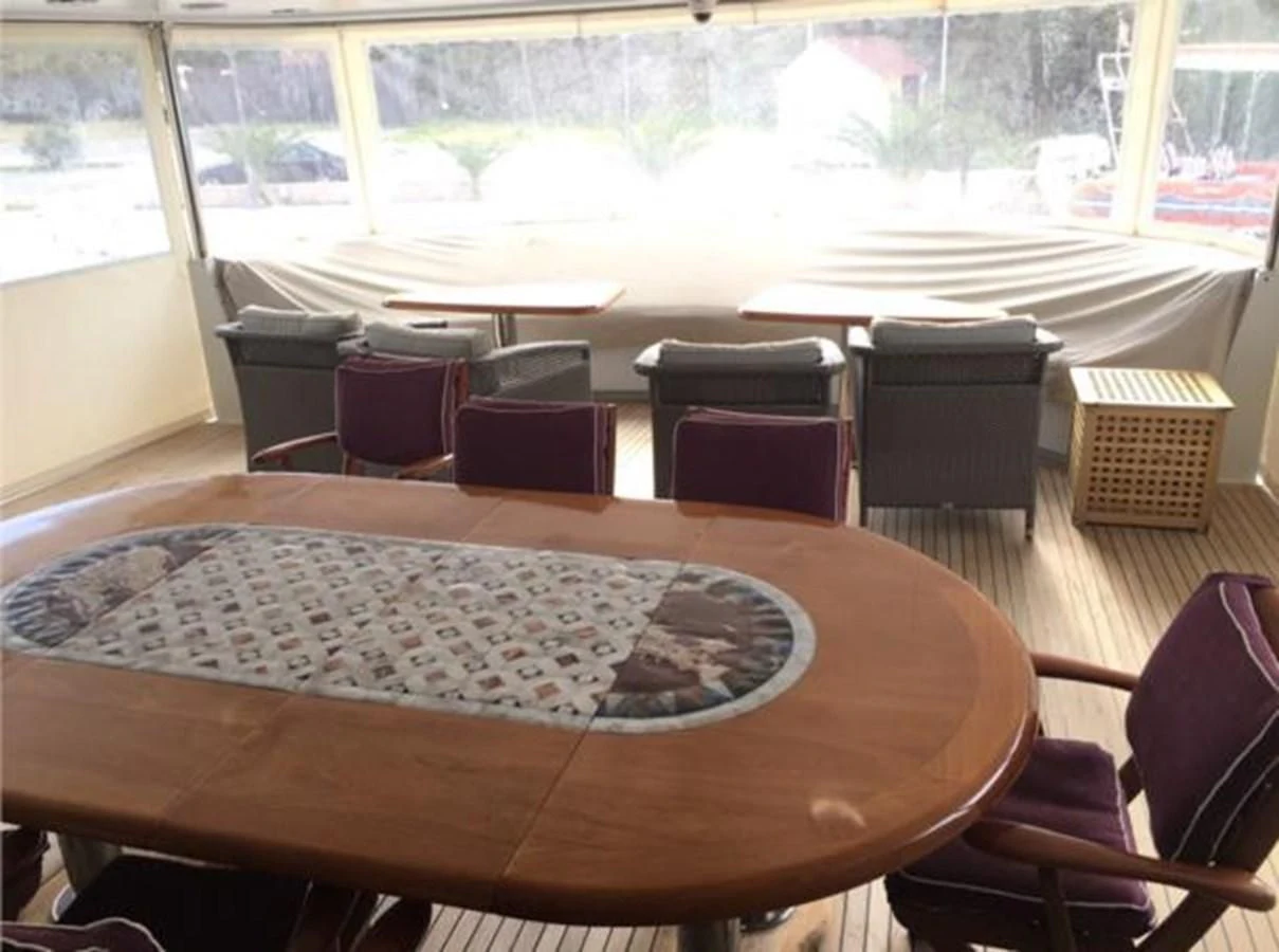 a room with a table and chairs aboard MYC Yacht for Sale