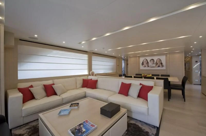 a living room with a white couch and red pillows aboard ELYSIUM Yacht for Sale