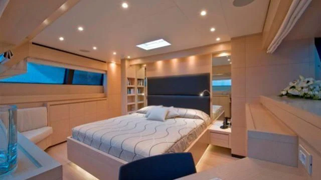 a bedroom with a bed and a desk aboard ELYSIUM Yacht for Sale